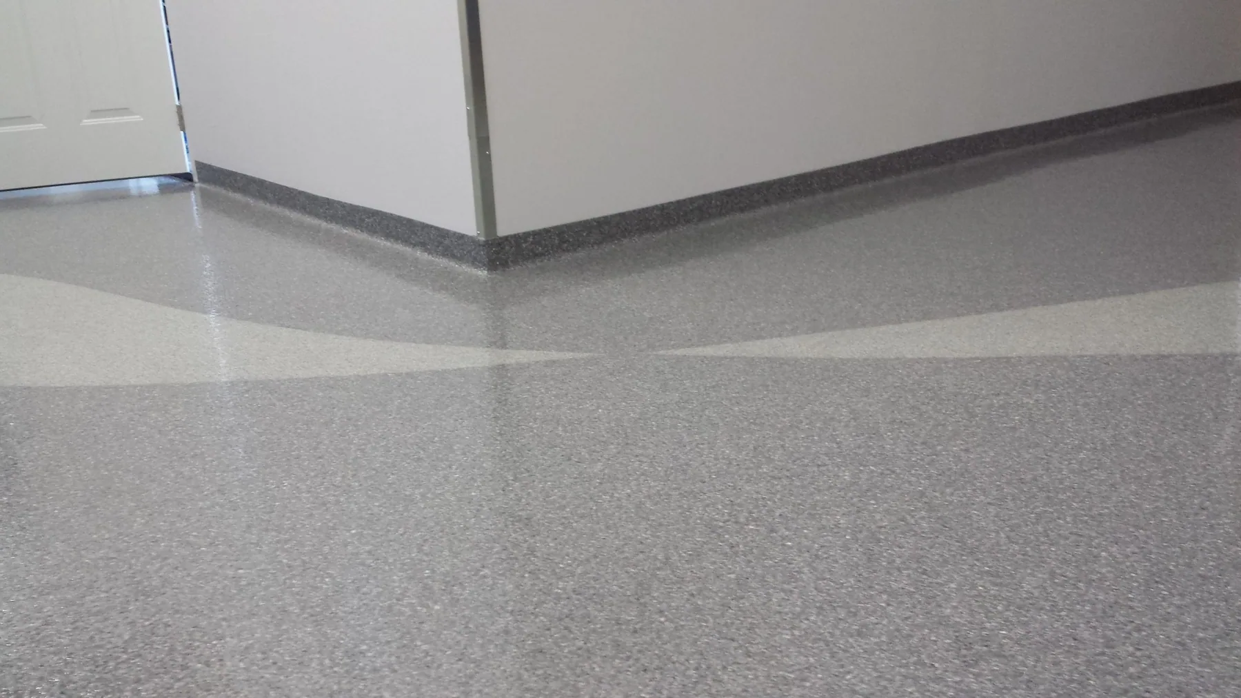 Gray decorative epoxy flake floor with matching cove base